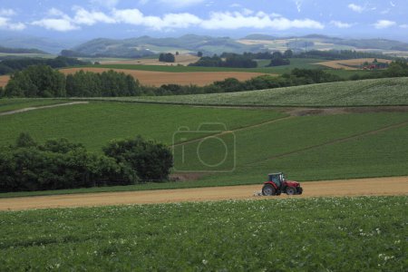 Téléchargez les photos : Paysage avec vue sur un tracteur sur le terrain - en image libre de droit