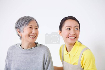 Téléchargez les photos : Heureux asiatique femme aidante aidant plus âgés asiatique femme à la maison - en image libre de droit