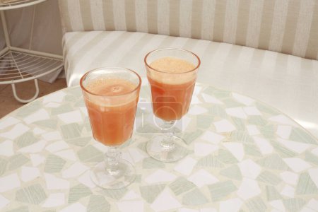 Photo for Fresh carrot juice in glasses on background, close up - Royalty Free Image
