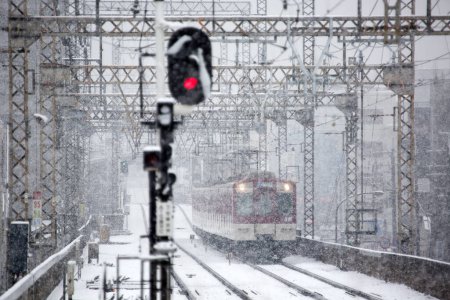 Photo for Train arriving at railway station during winter snowfall - Royalty Free Image