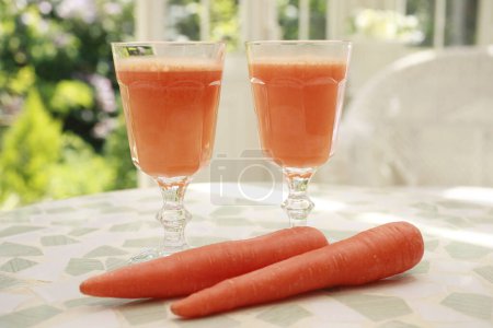 Photo for Fresh carrot juice in glasses on background, close up - Royalty Free Image