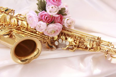 Photo for Close up of saxophone and pink roses, beautiful composition - Royalty Free Image
