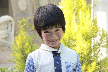 Photo for Cute Asian little boy smiling in summer garden - Royalty Free Image