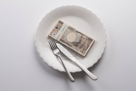 Foto de Un plato de dinero japonés, billetes de yen con tenedor y cuchillo - Imagen libre de derechos