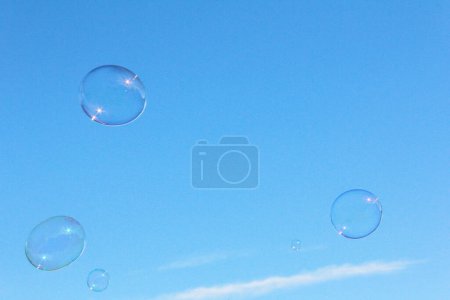 Téléchargez les photos : Bulles de savon sur fond bleu ciel - en image libre de droit