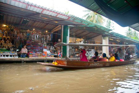Photo for Local people sell fruits, food and souvenirs at famous tourist attraction Damnoen Saduak floating market - Royalty Free Image