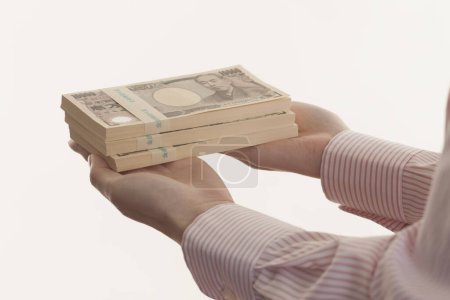 Téléchargez les photos : Mains féminines tenant de l'argent japonais, billets en yen isolés sur fond blanc - en image libre de droit
