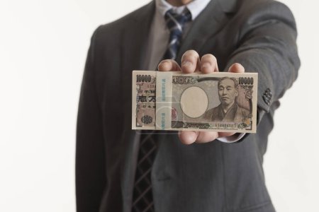 Foto de La mano del hombre sosteniendo el dinero japonés, billetes de yen - Imagen libre de derechos