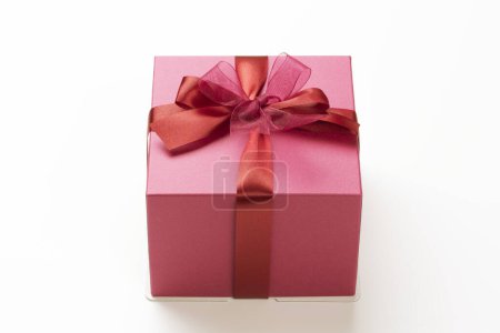 Téléchargez les photos : Un coffret cadeau rose avec un ruban rouge - en image libre de droit