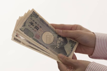 Photo for Female hands holding Japanese money,yen banknotes isolated on white background - Royalty Free Image