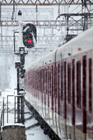 Foto de Tren que llega a la estación de tren durante las nevadas de invierno - Imagen libre de derechos