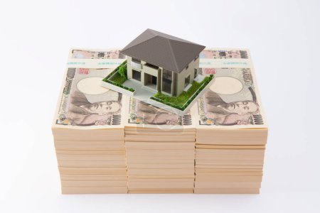 Foto de Billetes de yen japoneses y modelo de casa sobre fondo blanco - Imagen libre de derechos