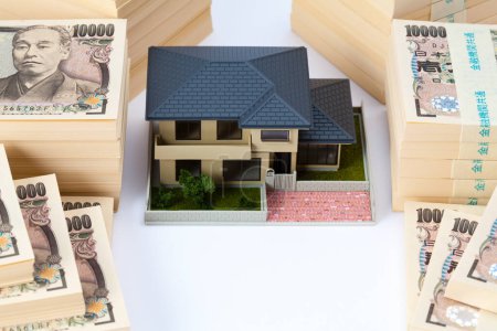Téléchargez les photos : Monnaie japonaise, pile de billets en yen et modèle de maison - en image libre de droit