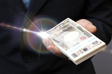 Téléchargez les photos : Main de yen japonais argent sur fond - en image libre de droit