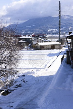 Téléchargez les photos : Paysage hivernal avec village enneigé en montagne - en image libre de droit