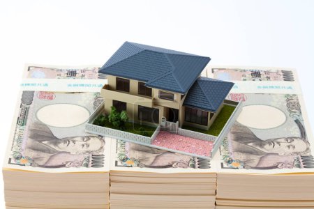 Foto de Moneda japonesa, pila de billetes de yen y modelo de casa - Imagen libre de derechos