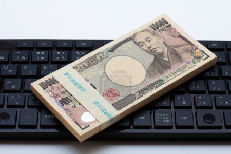 Téléchargez les photos : Billets en yen japonais sur fond de clavier. argent japonais - en image libre de droit