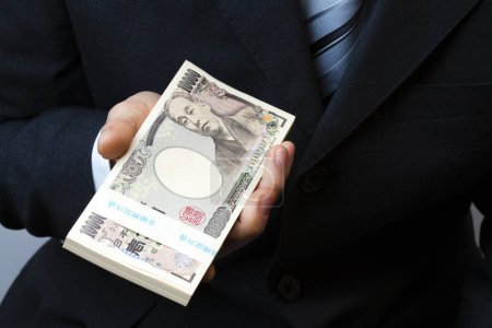 Téléchargez les photos : Main de yen japonais argent sur fond - en image libre de droit