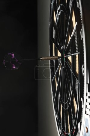 Photo for Dart arrow hitting in the target center of dartboard - Royalty Free Image