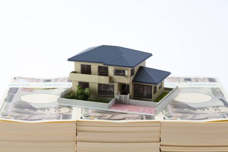 Photo for Japanese currency, pile of yen banknotes and house model - Royalty Free Image