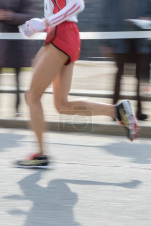 Téléchargez les photos : Jambes de l'athlète jogging en mouvement flou, section basse - en image libre de droit