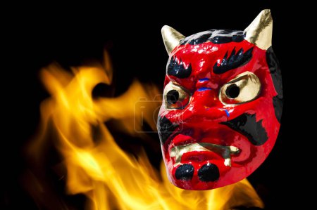 Máscara de demonio japonesa con fuego en el fondo