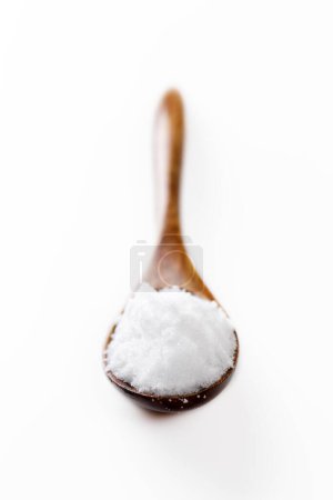 Foto de Una pila de azúcar blanco en una cuchara de madera. - Imagen libre de derechos