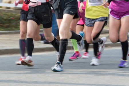 Téléchargez les photos : Jambes des athlètes jogging en mouvement flou, section basse - en image libre de droit