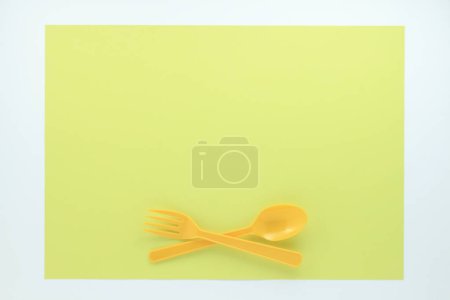 Photo for Top view of bright plastic cutlery on light green background - Royalty Free Image