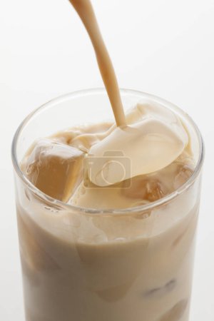 Téléchargez les photos : Un verre de café avec du lait et de la glace - en image libre de droit