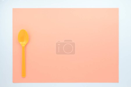 Photo for Top view of bright plastic spoon on red background - Royalty Free Image