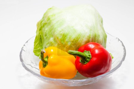 Photo for Fresh vegetables on plate, cabbage and peppers on white background - Royalty Free Image