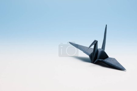 Téléchargez les photos : Un oiseau origami noir sur une surface blanche - en image libre de droit