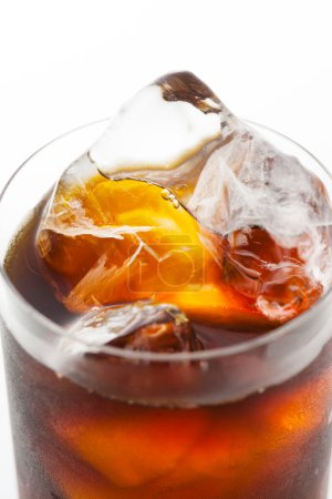 Téléchargez les photos : Vue rapprochée de boissons froides au cola avec glaçons en verre sur fond blanc. - en image libre de droit