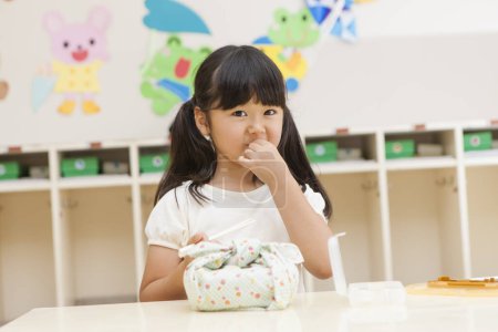 Foto de Asiático niña con almuerzo y palillos listo a tener comida en la escuela - Imagen libre de derechos