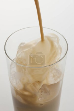 Photo for A glass of coffee with  pouring milk and ice - Royalty Free Image