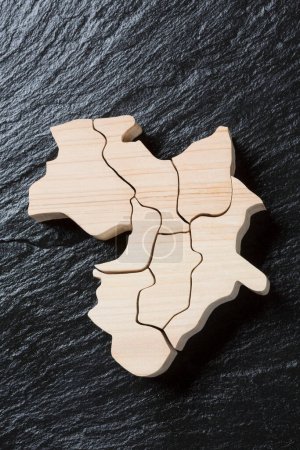 Foto de Pieza de mapa de madera sobre fondo de madera negro - Imagen libre de derechos