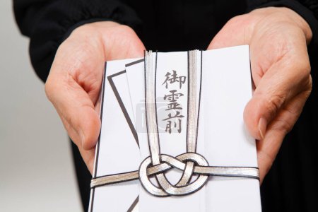 Sac traditionnel japonais enveloppant de l'argent pour les funérailles dans les mains