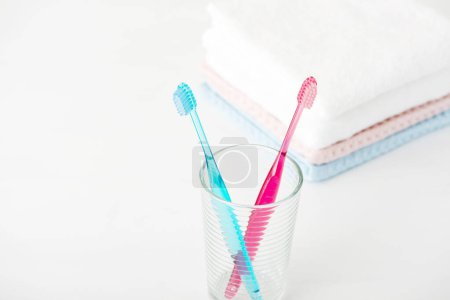 Foto de Cepillos de dientes y toallas sobre fondo blanco, de cerca - Imagen libre de derechos