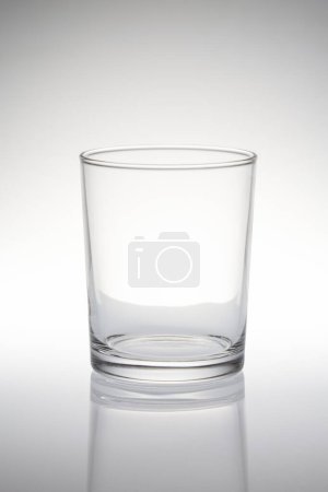 Téléchargez les photos : Vue rapprochée du verre vide sur fond gris - en image libre de droit