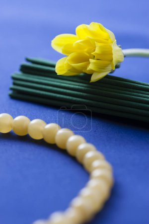 Téléchargez les photos : Perles blanches et une fleur jaune - en image libre de droit