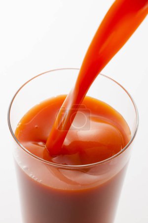 Foto de Un vaso de jugo de tomate rojo en el fondo, de cerca - Imagen libre de derechos