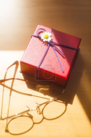 Téléchargez les photos : Boîte cadeau avec fleur et ruban sur fond - en image libre de droit