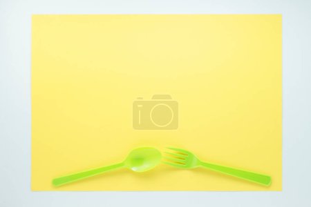Téléchargez les photos : Vue de dessus des couverts en plastique brillant sur fond jaune - en image libre de droit