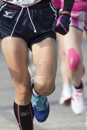 Téléchargez les photos : Jambes des athlètes jogging en mouvement flou, section basse - en image libre de droit