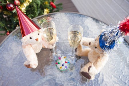 Photo for Close-up view of champagne glasses and funny teddy bears in christmas hats - Royalty Free Image