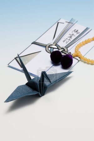 Foto de Un pájaro de origami doblado con un collar de cuentas - Imagen libre de derechos