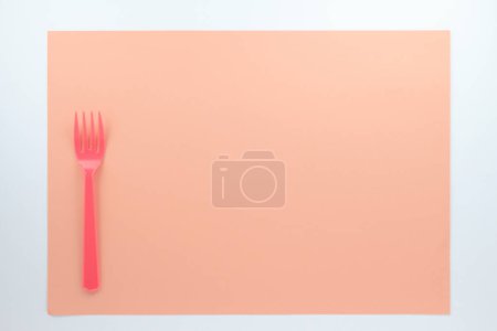 Téléchargez les photos : Vue de dessus de fourche en plastique rouge sur fond beige - en image libre de droit