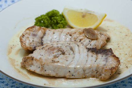 Photo for Plate of baked fish with broccoli and a lemon - Royalty Free Image