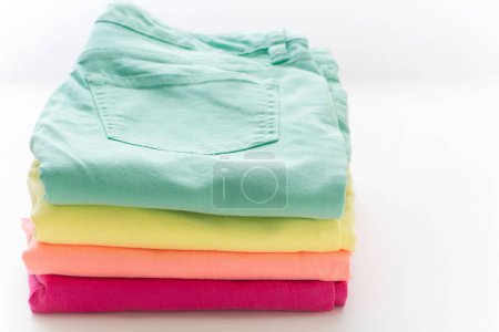 Photo for A stack of folded shirts on  white  background, close up - Royalty Free Image